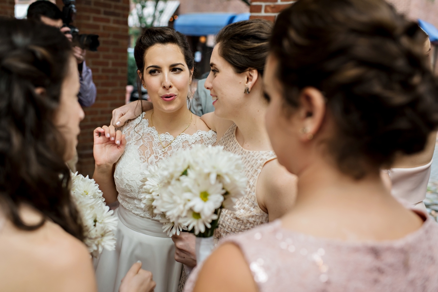 A bride and her bridesmaids laugh and celebrate after the wedding.